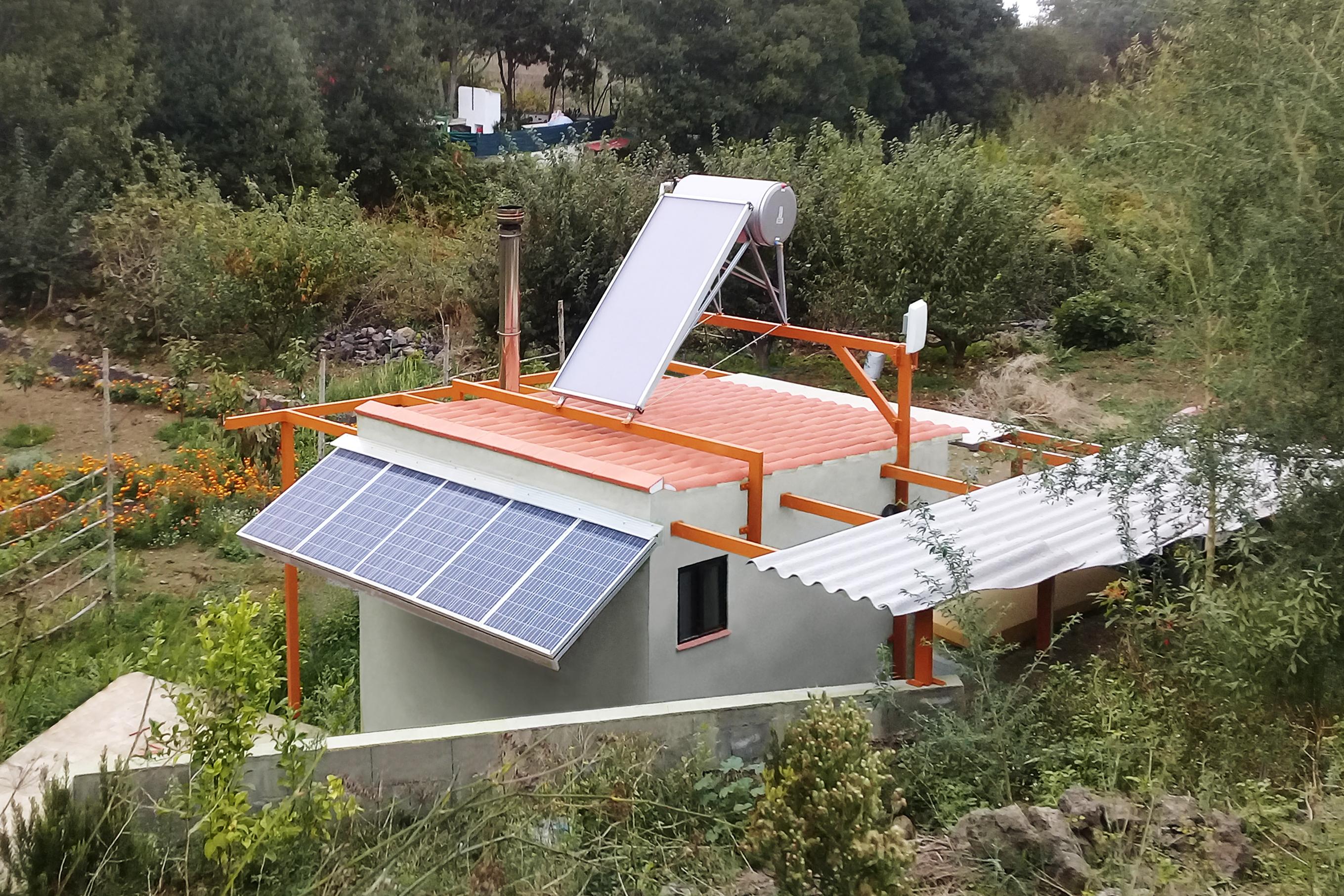 Sur la photo, on distingue clairement les panneaux solaires, le chauffe-eau solaire et l'antenne du système du Jardin Intelligent