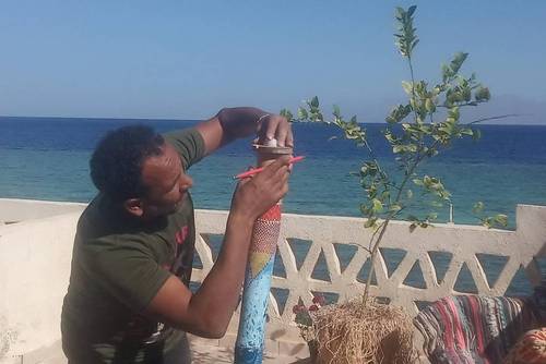 Le directeur de la représentation régionale de Symbiosei installe un capteur WiFi de monitoring du microclimat dans un boîtier décoratif en matériaux naturels